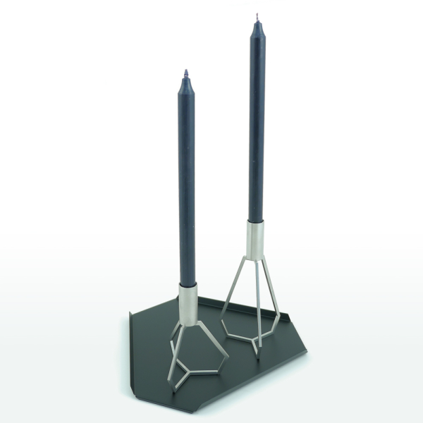 En maskulint og klassisk kombination med TRIPOD lysestager i rustfri stål på sort metal·bakke